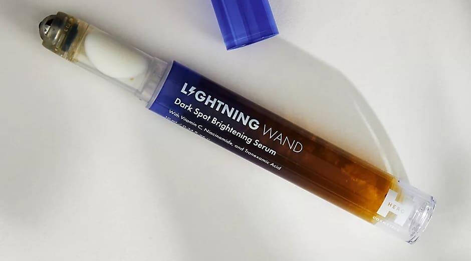 A bottle of skincare serum with a blue cap and dropper, amber liquid solution.